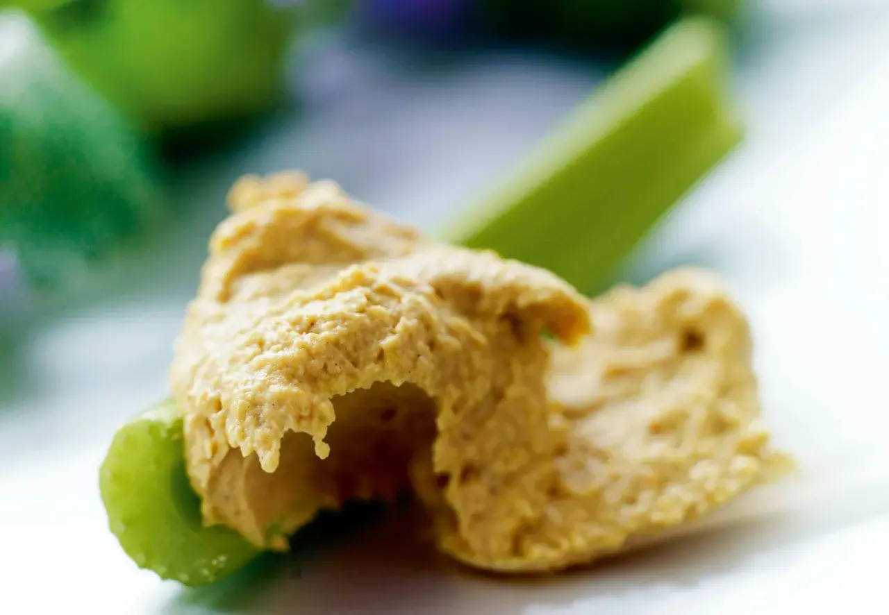 En klick krämig hummus på en krispig selleristjälk. Ett enkelt och gott recept på hummus som passar perfekt som mellanmål.