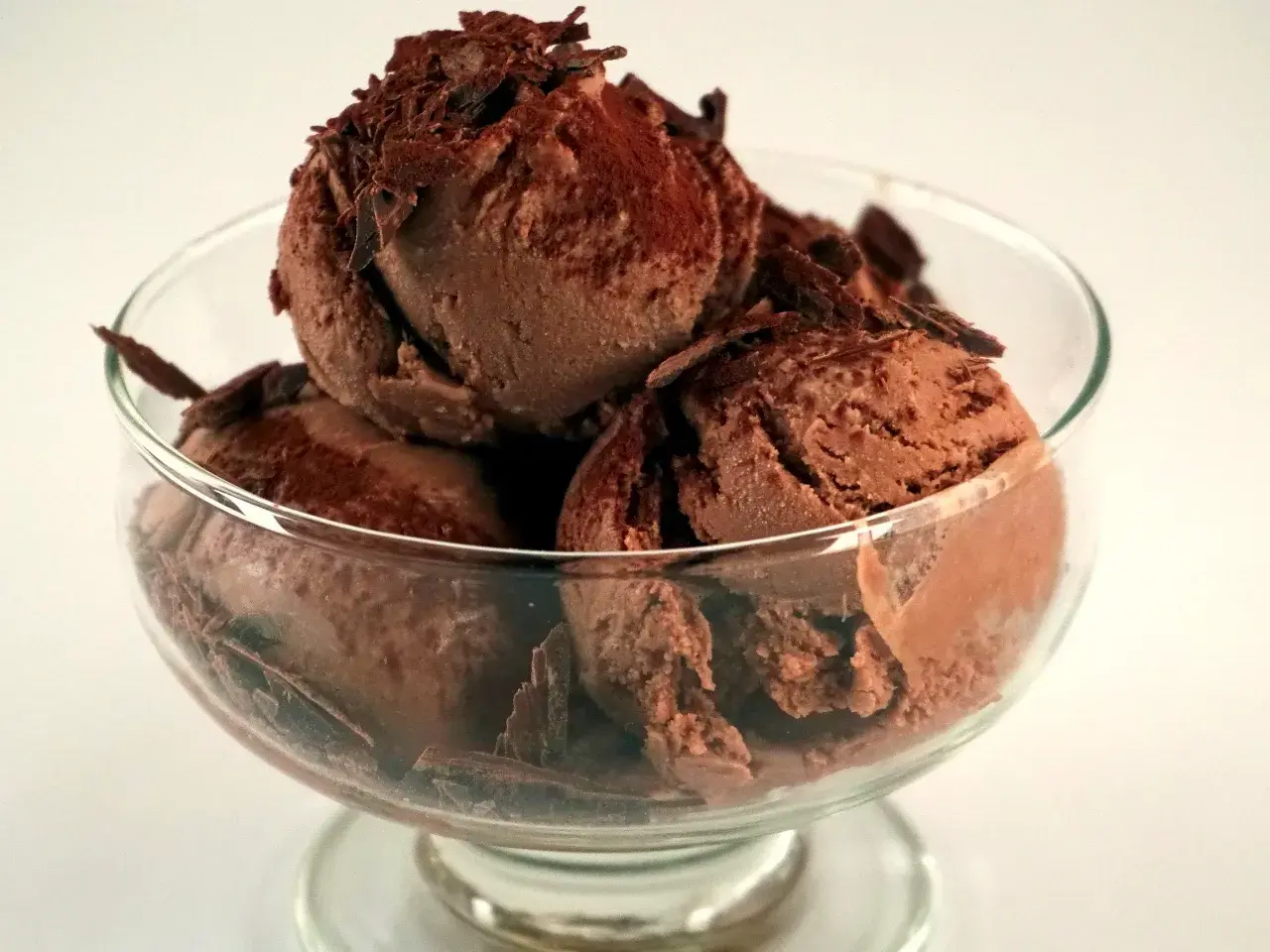 En skål med krämig chokladglass, toppad med chokladspån. Perfekt för ett enkelt chokladglass recept.