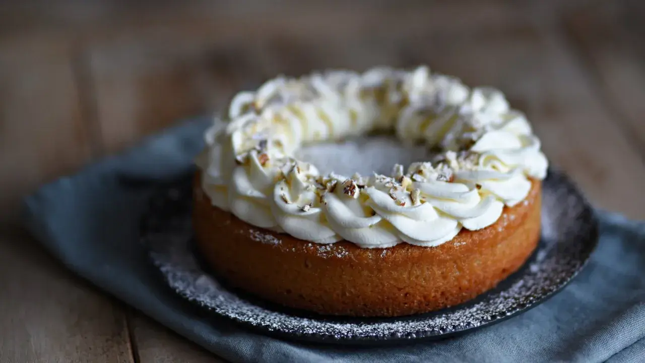 En kladdkaka med semla-inspirerad gräddkrans och hackade nötter. En dröm för alla fikasugna!