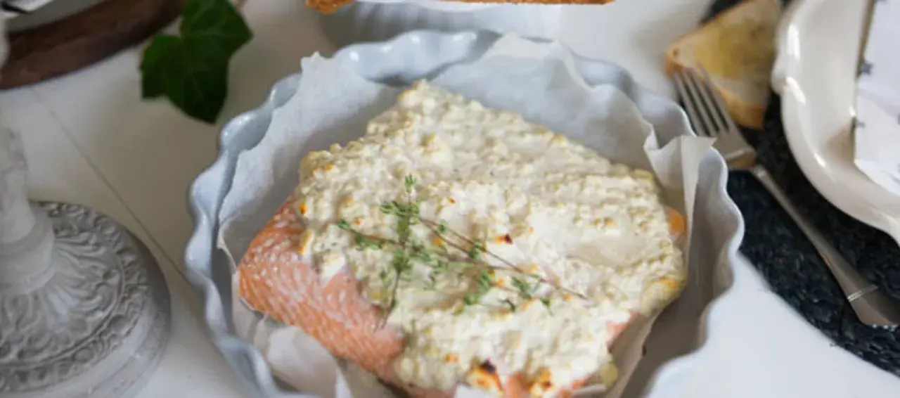 Lax med fetaost och crème fraiche, toppad med färsk timjan, serveras i en ugnsform. En härlig rätt för en mysig middag.