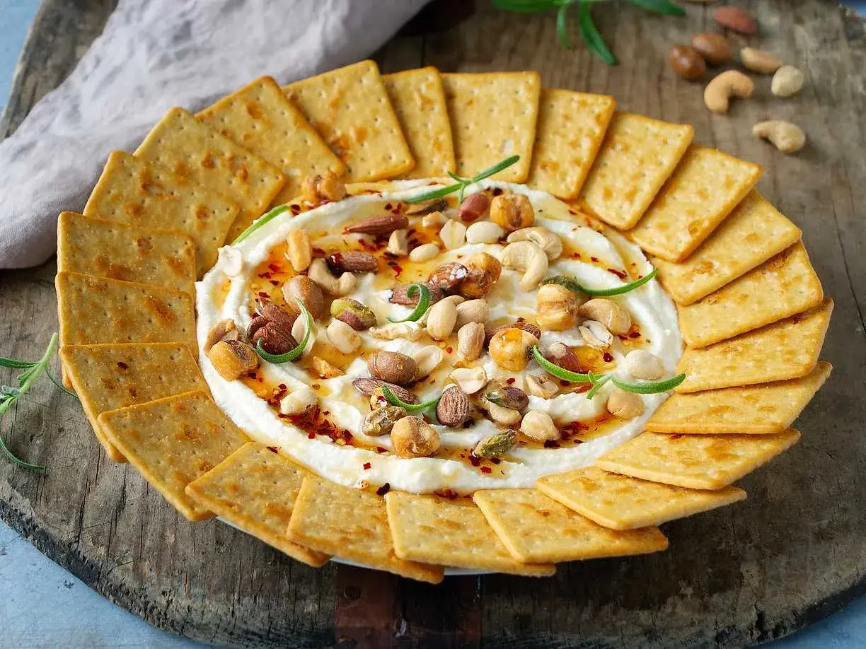 Krämig vispad fetaost med honung, nötter och chili, serverad med kex. En perfekt dipp för alla tillfällen.