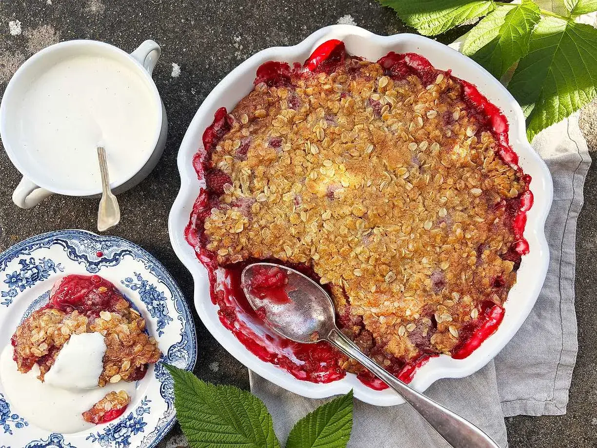 En härlig hallonpaj med krispigt täcke, serverad med vaniljsås. Ett perfekt hallonpaj recept för sommaren.