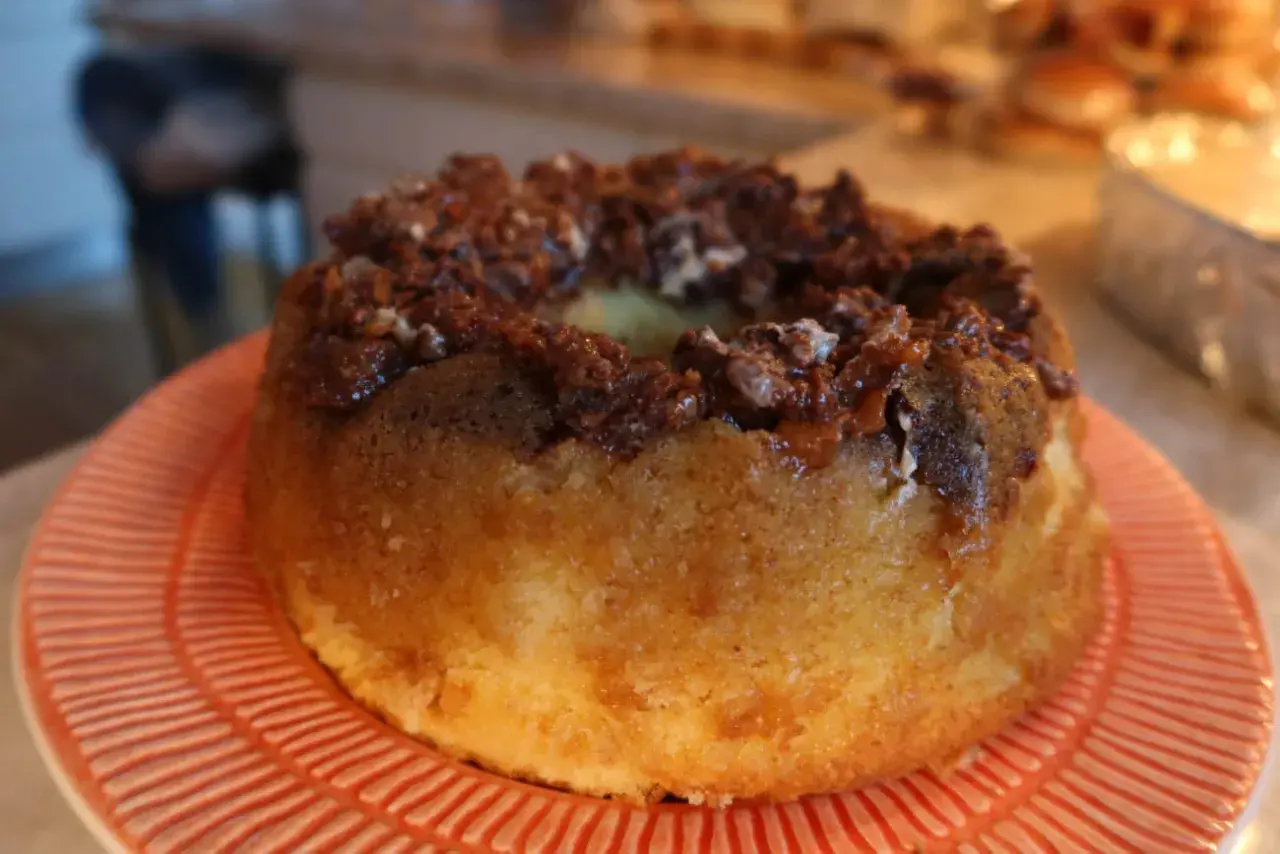 En saftig sockerkaka med en härlig chokladtopping, serverad på en orange tallrik.