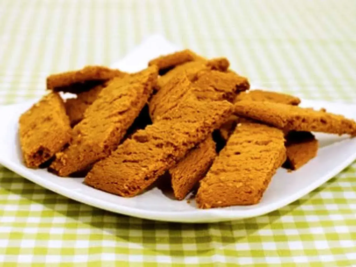 En hög med gyllene kolakakor på en vit tallrik, redo att avnjutas. Perfekt för ett enkelt kolakakor recept.