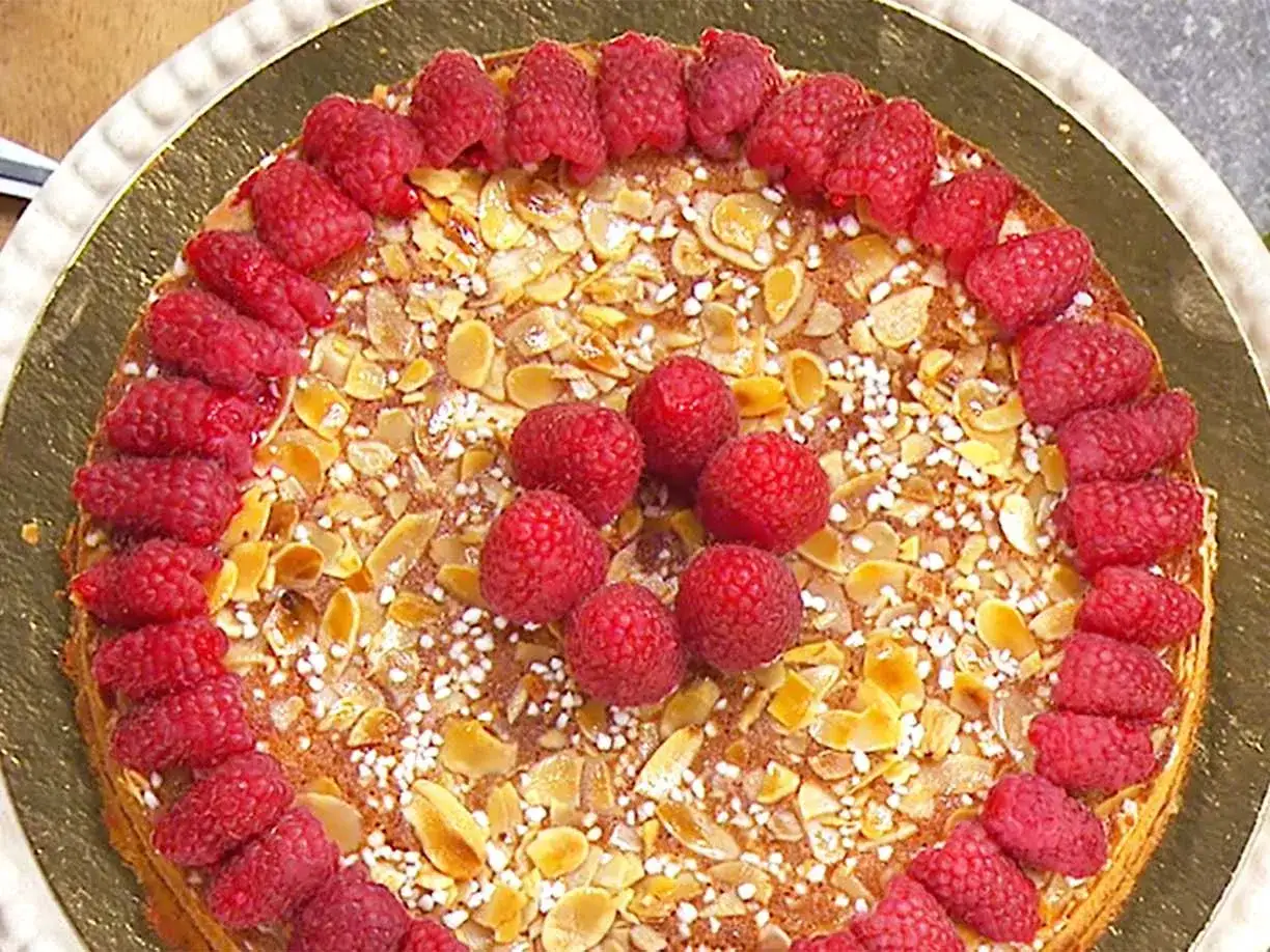 En vacker mandelkaka med citron, toppad med färska hallon och flagad mandel. Perfekt för fikat!