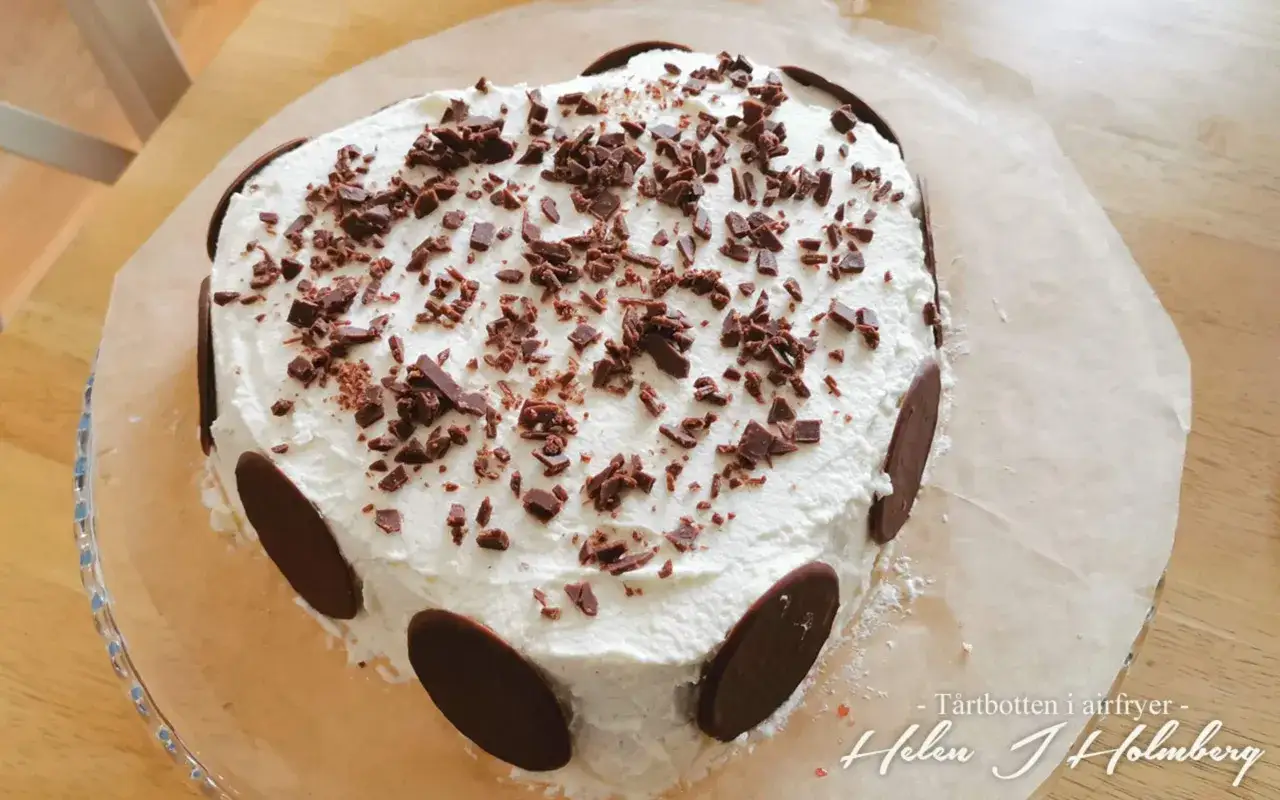 Hjärtformad tårta med fluffig grädde, chokladströssel och chokladdekorationer längs kanten. En saftig tårtbotten som ser utsökt ut!