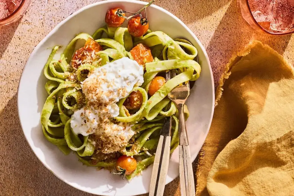 Gr&ouml;n pasta med kr&auml;mig burrata, k&ouml;rsb&auml;rstomater och str&ouml;br&ouml;d. En h&auml;rlig burrata pasta som ser uts&ouml;kt ut.