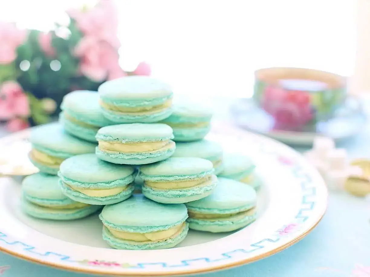 Blå macarons med vaniljkräm på en tallrik. Perfekt för ett macarons recept.