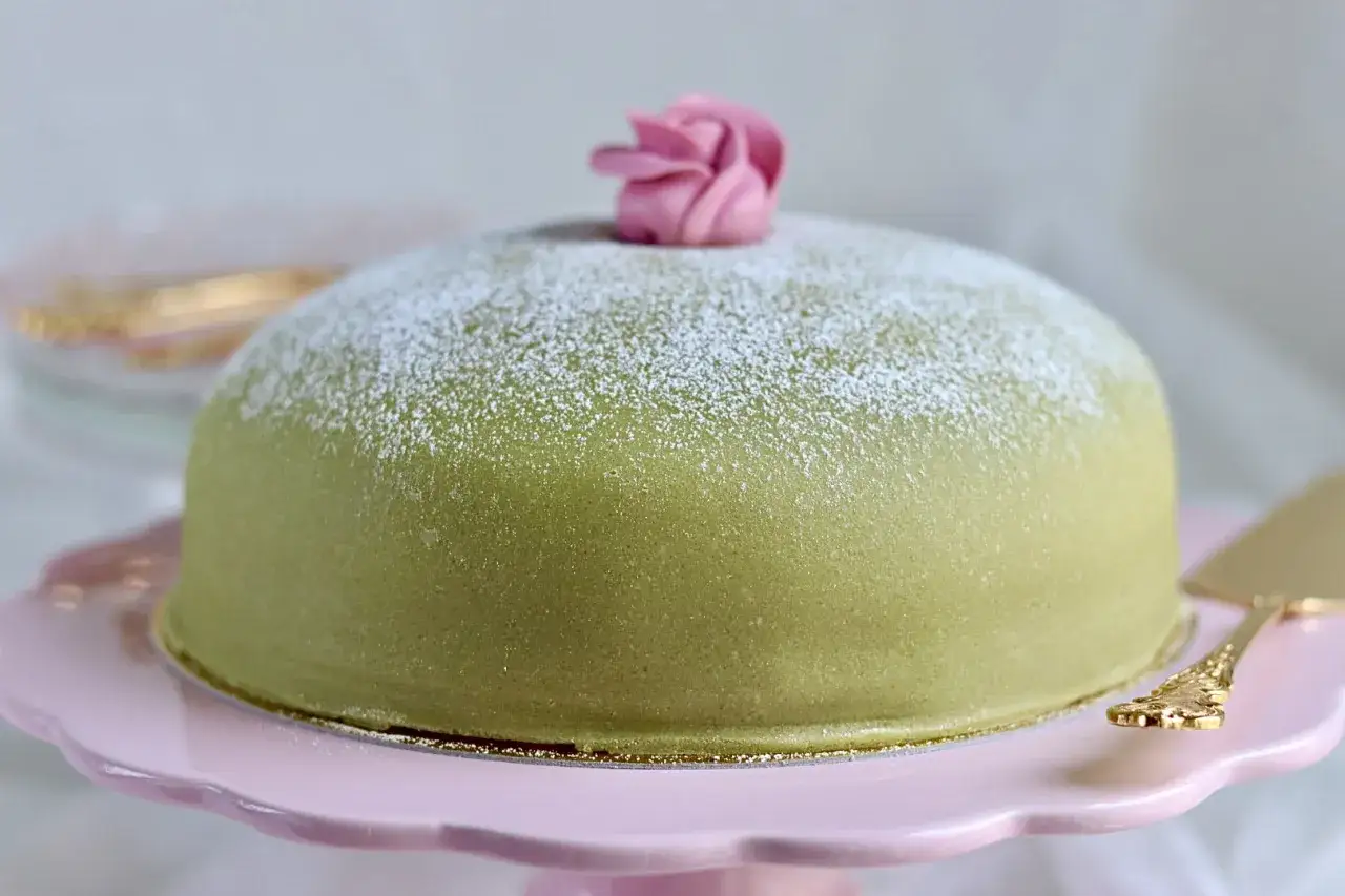 Grön prinsesstårta med rosa marsipanros och pudersocker. Perfekt för ett enkelt marsipan recept.