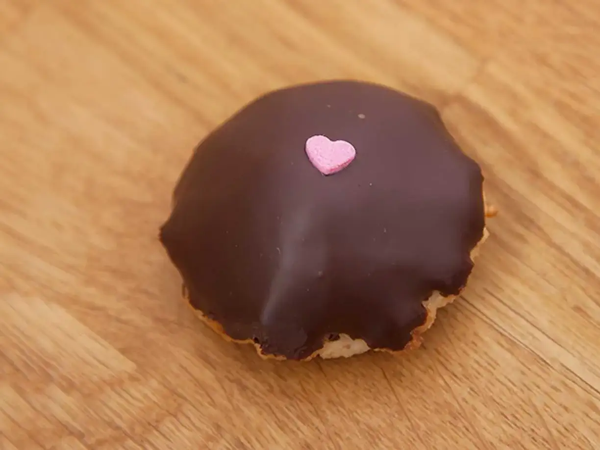 En chokladbiskvi med ett rosa hjärta på en träbakgrund. Perfekt för alla hjärtans dag eller bara för att visa lite kärlek.
