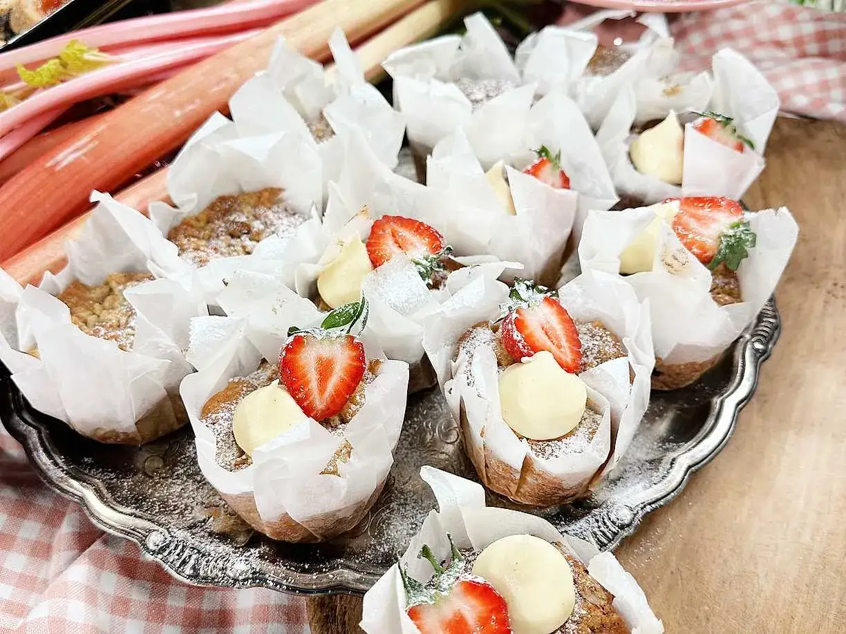 Rabarber muffins med jordgubbar och vaniljkräm på ett silverfat.