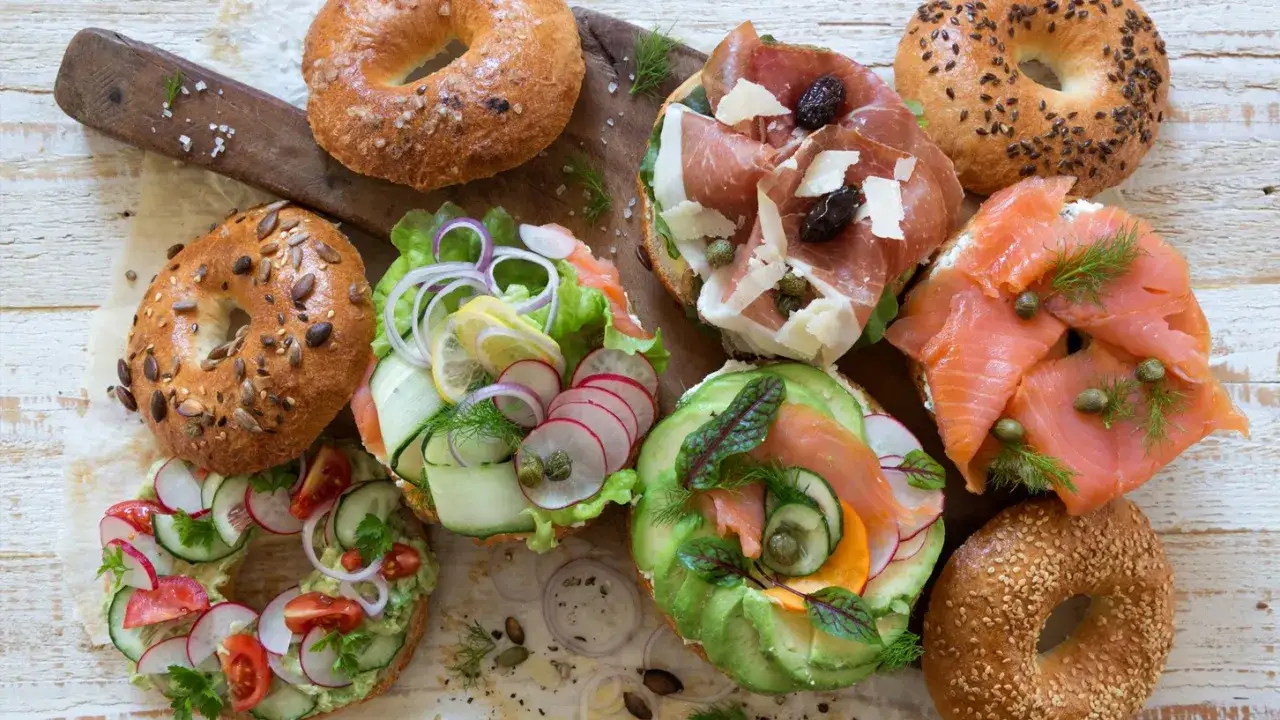 Färgglada bagels med lax, prosciutto, avokado och grönsaker. Perfekt inspiration för ditt nästa bagels recept!