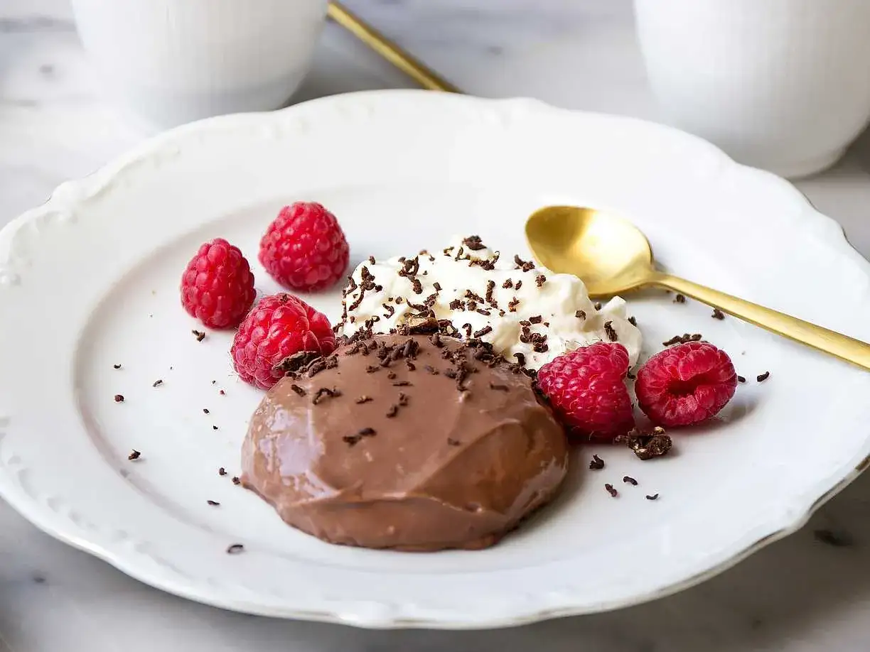 En krämig chokladpudding med hallon och vispgrädde, perfekt för ett enkelt chokladpudding recept.