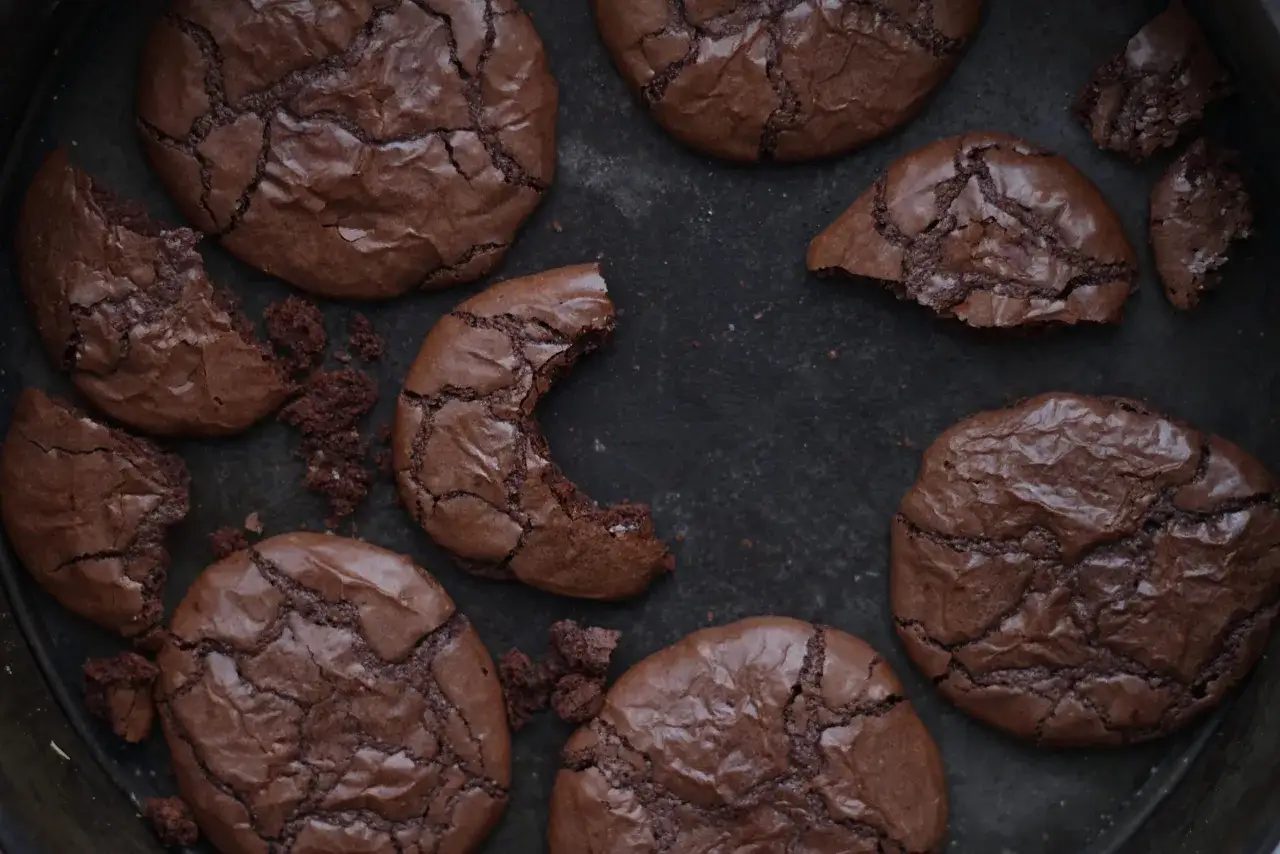 Mörka, spröda chokladkakor med en härlig Nutella-smak. Några är hela, andra har bitits i och smulor ligger utspridda.
