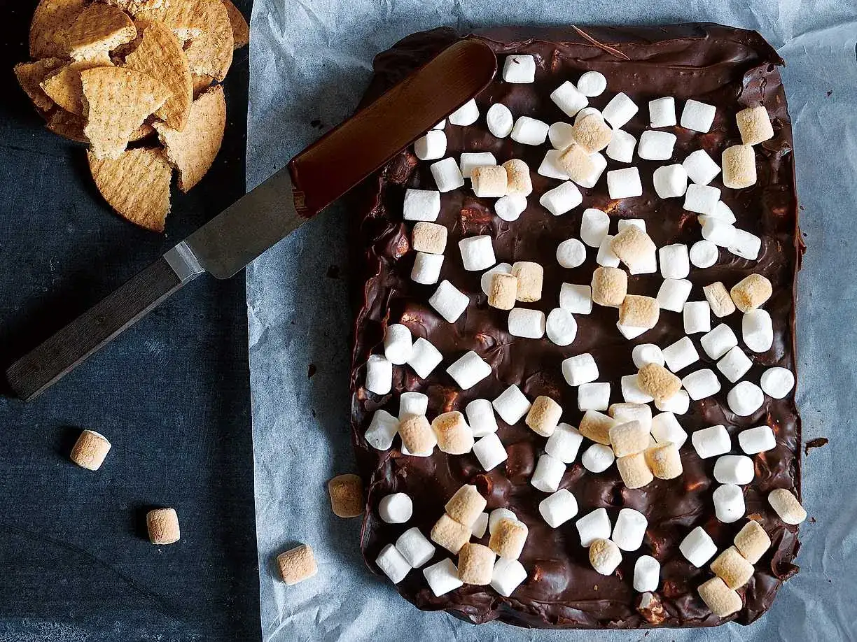 S'mores i ugn: chokladkaka med marshmallows och kex. En kniv ligger på bakplåtspapperet.