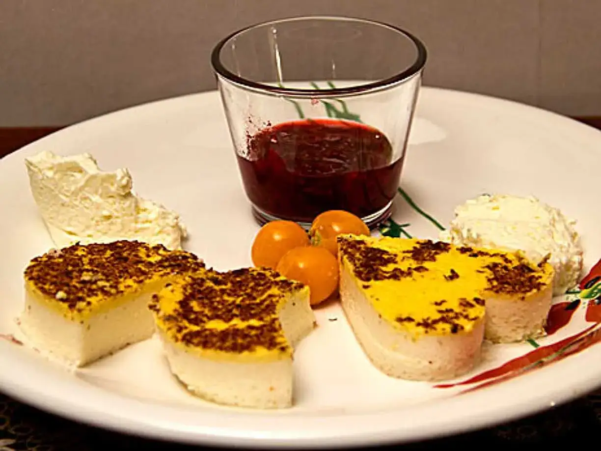 Kalvdans recept: Portioner av gul och vit dessert med klickar av grädde, physalis och en liten skål med röd sylt.