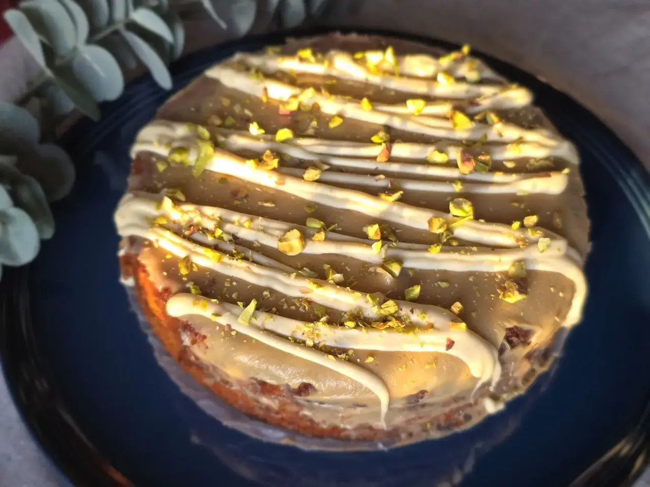 En l&auml;cker torta caprese med vit chokladglasyr och hackade pistagen&ouml;tter.