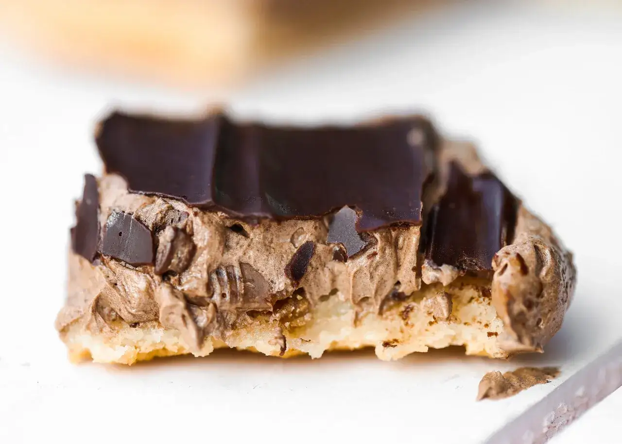 En närbild av en chokladbiskvi med krämig chokladfyllning och mörk chokladglasyr. Perfekt för fika, som om de vore biskvier i långpanna.