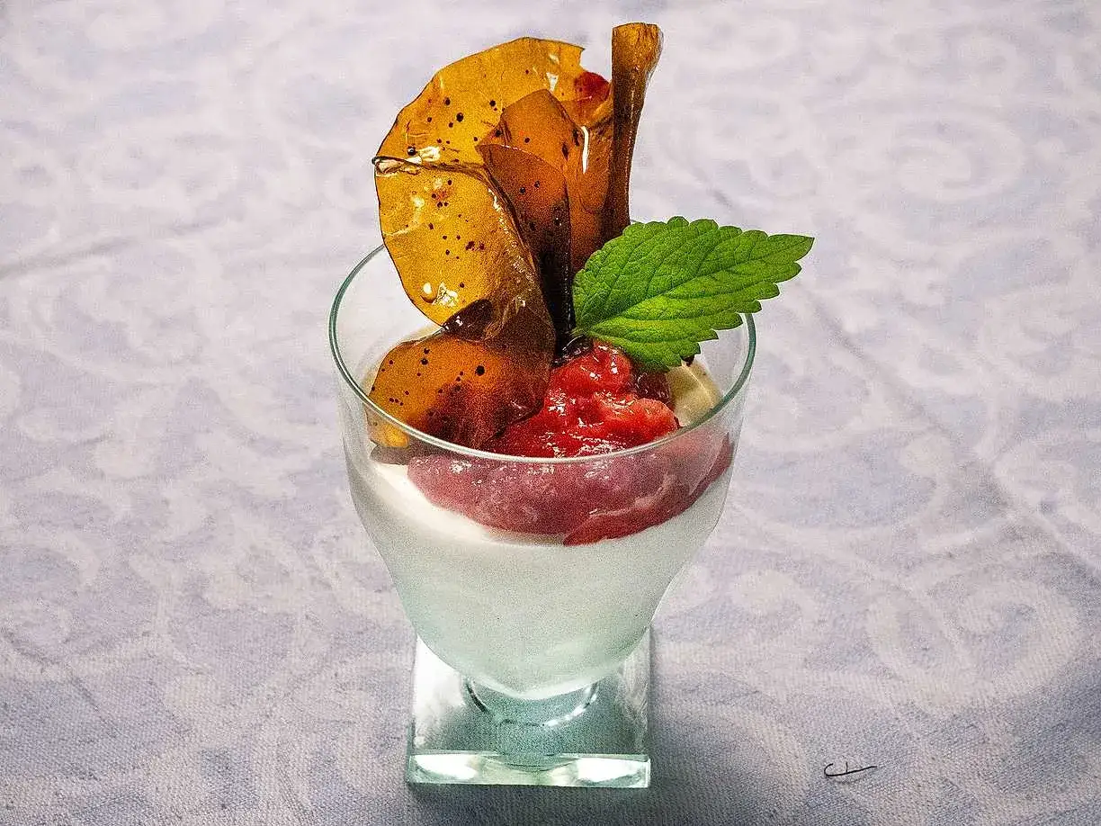 Krämig pannacotta med rabarberkompott, toppad med karamell och mynta. En härlig dessert som passar perfekt till fikat.