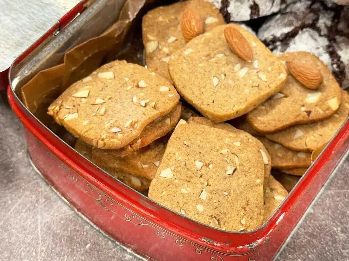 En burk med franska skurna pepparkakor, toppade med mandlar. Perfekta till fikat!