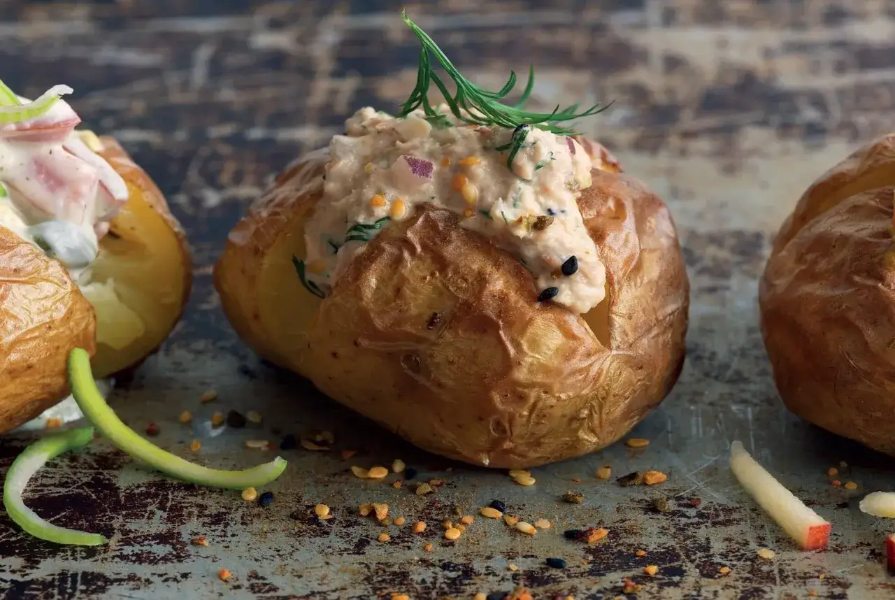 Bakad potatis med en krämig fyllning av lax och dill, toppad med färska örter. En härlig bakad potatis fyllning som passar perfekt till middagen.
