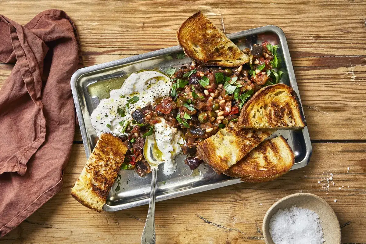 En krämig ost med en smakrik grönsaksröra och grillade brödskivor. Perfekt som förrätt eller lätt lunch, och en inspiration för vad man kan grilla.