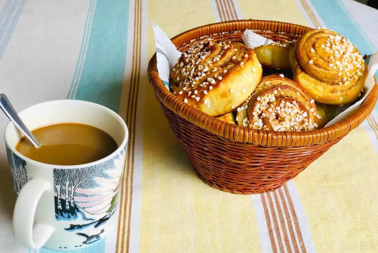 En korg med nybakade kanelbullar, redo att avnjutas med en kopp kaffe. Ett perfekt kanelbulle recept!