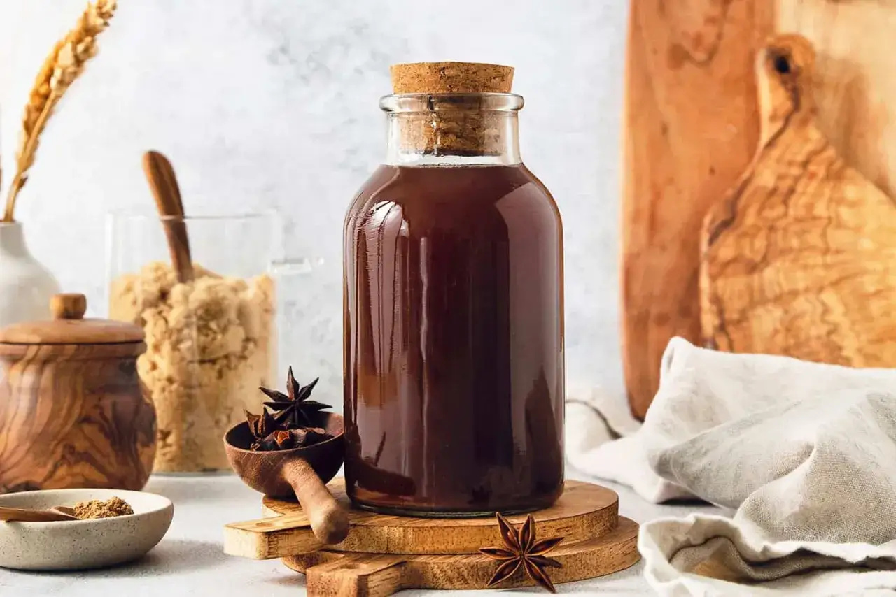 Flaska med m&ouml;rkt chai syrup, stj&auml;rnanis och farinsocker. Perfekt f&ouml;r ditt chai syrup recept.