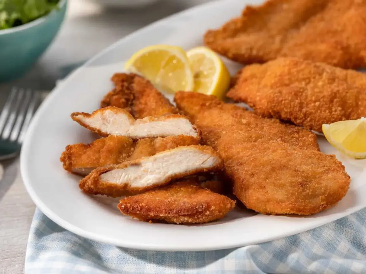 Krispig kyckling i airfryer, perfekt tillagad och serverad med citronklyftor.