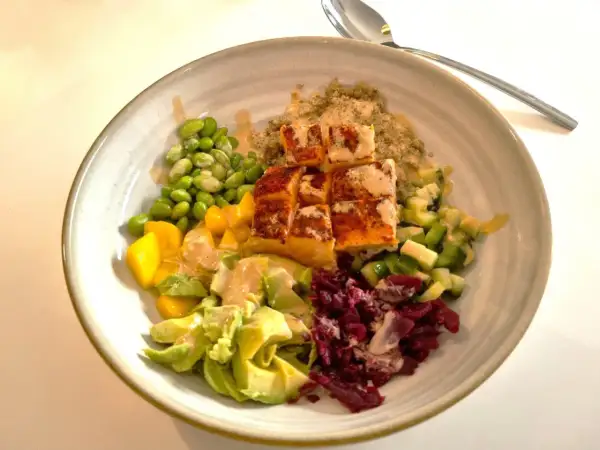 En färgglad bowl med lax, quinoa, edamamebönor, mango, avokado och rödbetor. Ett perfekt bowl recept för en hälsosam måltid.