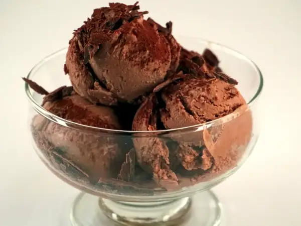 En skål med krämig chokladglass, toppad med chokladspån. Perfekt för ett enkelt chokladglass recept.