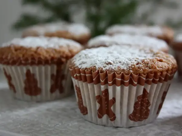 Pepparkaksmuffins recept: Nybakade muffins med pepparkakssmak, pudrade med florsocker och dekorerade med pepparkaksfigurer.