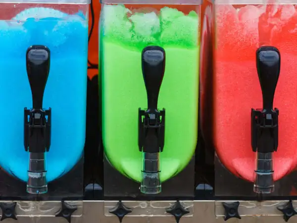 Tre behållare med blå, grön och röd slush. Perfekt för ett somrigt slush recept!
