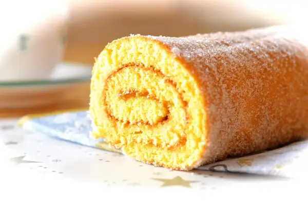En saftig rulltårta med sockerströssel, perfekt för ett enkelt rulltårta recept.