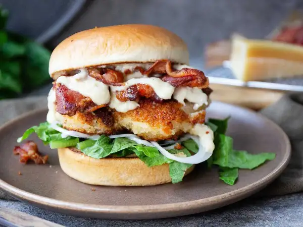 En saftig kycklingburgare med krispigt bacon och krämig dressing. Perfekt för ett hamburgerdressing recept.