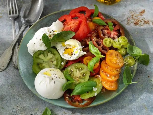 En krämig burrata med en blandning av färgglada tomater och färsk basilika. Ett enkelt och gott burrata recept.